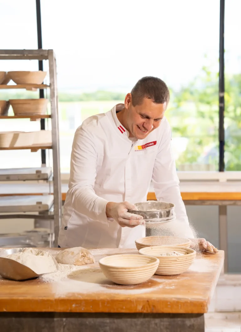 Philipp Stoiber streut Mehl auf Brotkörbe - handwerkliche Bäckerei Konditorei Weinviertel